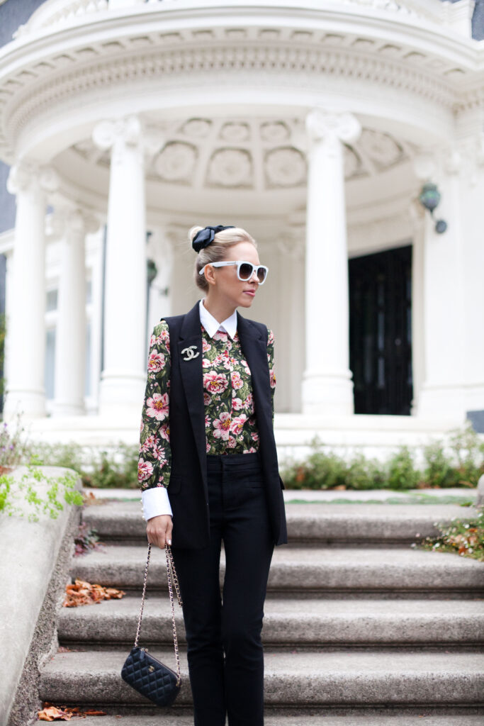 zara PEARL BUTTON BLOUSE WITH BOW | Zara printed blouse with bow styled by top US fashion blog, Lombard and Fifth: image of a blonde woman wearing a Zara floral blouse, Zara pants, Chanel brooch, Valentino heels and a Chanel bag.