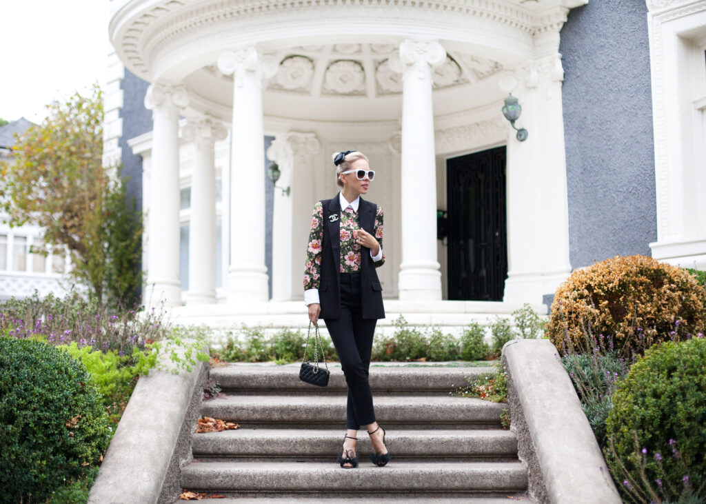 zara PEARL BUTTON BLOUSE WITH BOW | Zara printed blouse with bow styled by top US fashion blog, Lombard and Fifth: image of a blonde woman wearing a Zara floral blouse, Zara pants, Chanel brooch, Valentino heels and a Chanel bag.