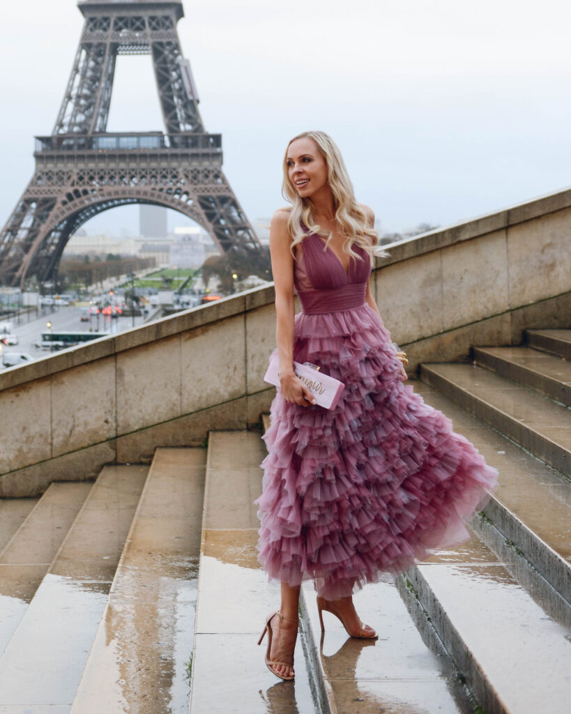 Julie Voss bracelets and earrings, violet marchesa notte gown at eiffel tower in Paris | Top San Francisco fashion blog, Lombard and Fifth, is traveling in Paris and features some Julie Vos jewelry: image of a blonde woman in front of the Eiffel Tower wearing Julie Vos cuff and earrings, Marchesa Notte dress, Alice & Me Clutch, Stuart Weitzman sandals