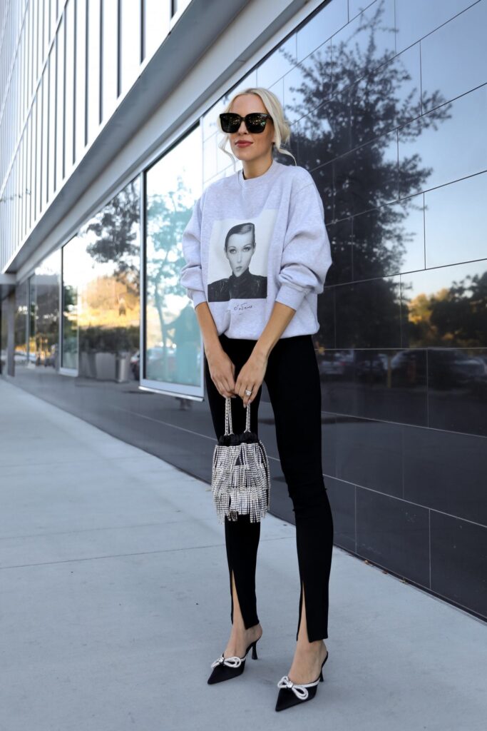 Casual glam style, Anine Bing Ramona Sweatshirt AB X TO Kate sweatshirt with H&M slit detail black leggings and satin embellished double bow rhinestone mules from Outdazl. Fall style, by Veronica Levy of Lombard & Fifth.