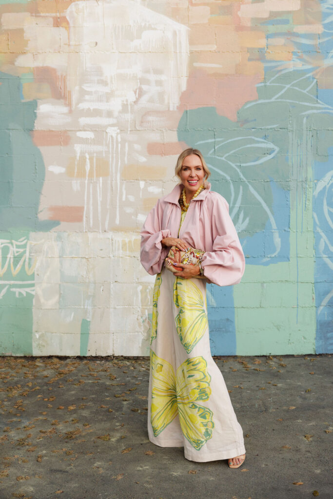 pastel spring outfit with pink cropped jacket yellow printed dress and statement necklace