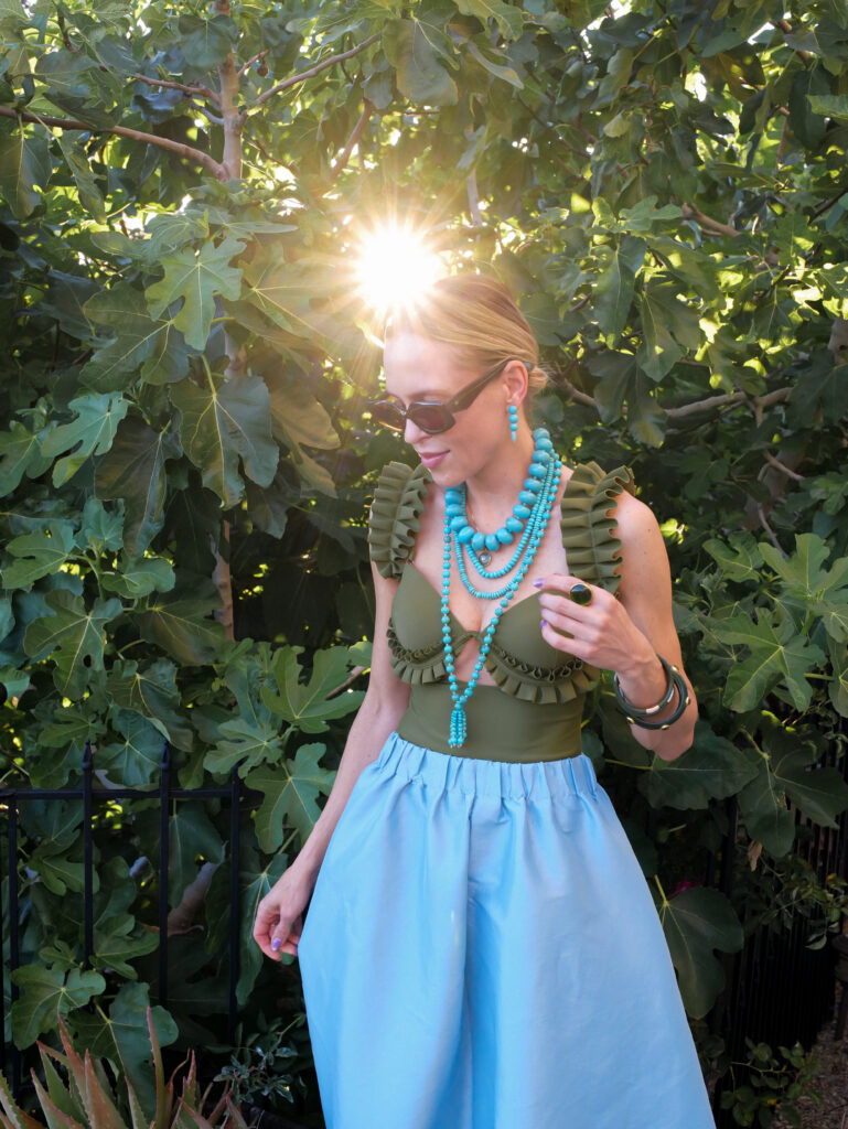 Bold turquoise jewelry trend styled with designer resortwear and colorful vacation-ready fashion pieces.