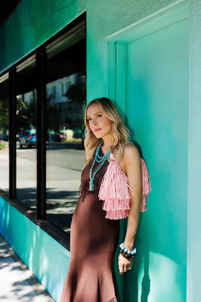 Fashion influencer Veronica Levy styling a monochromatic fringe dress with a statement fringe handbag for a modern summer outfit.