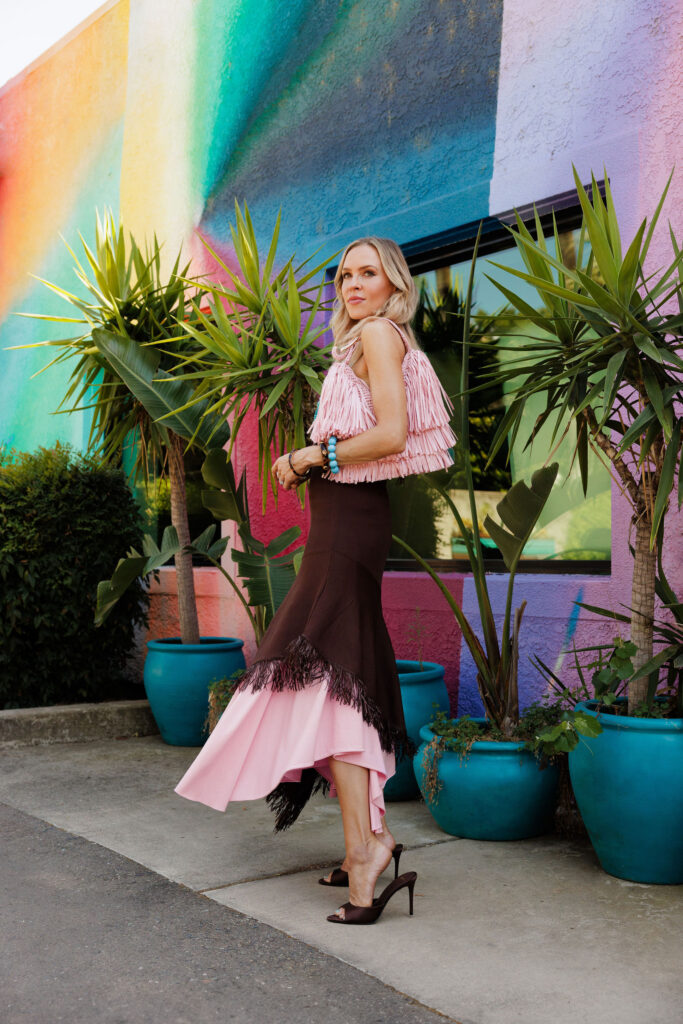 Veronica Levy walking in a fringe-trimmed dress demonstrating the movement and texture of the fringe trend.