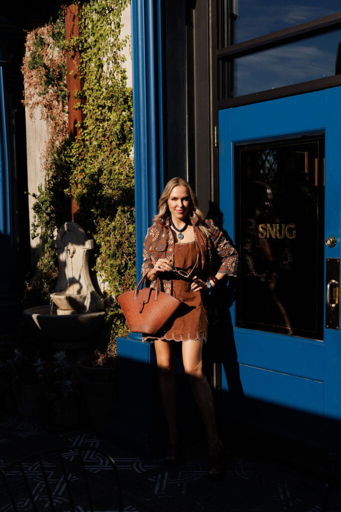 Woman wearing chocolate brown summer fashion styled with statement accessories and neutral tones.