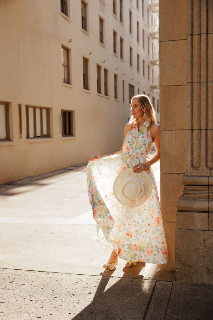 Floral Needle & Thread dress photographed among blooming cream roses at sunset