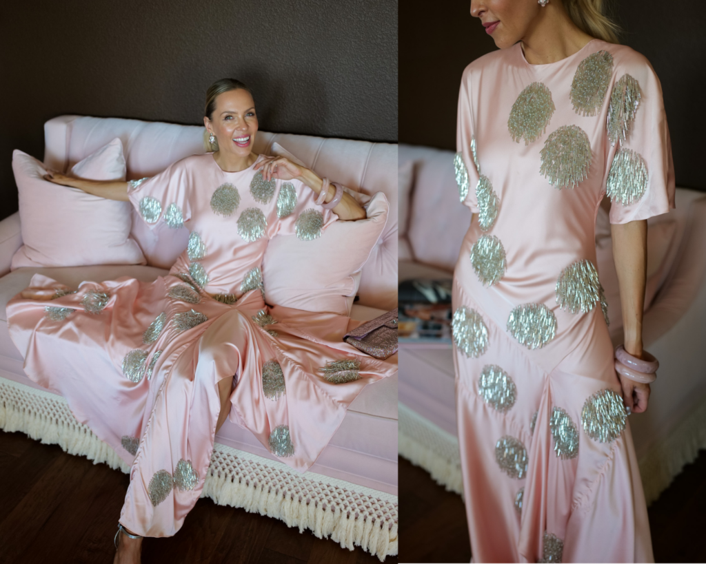 Woman wearing a blush pink satin polka dot embellished maxi dress while sitting on a blush sofa, showcasing the Ballet Pink fashion trend.