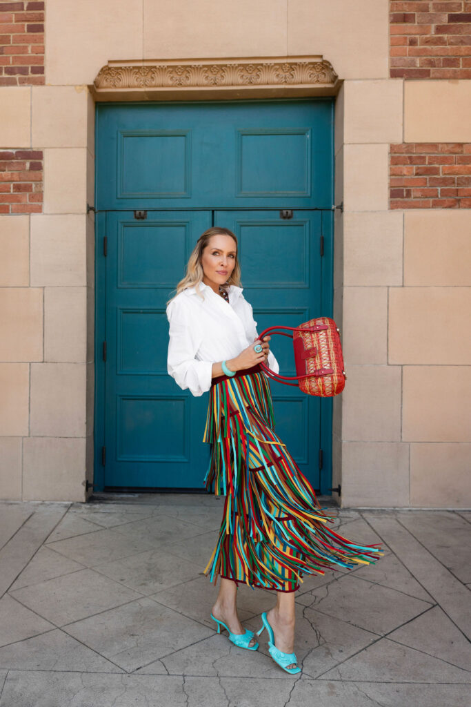 Veronica Levy Lombard & Ffifth wearing a white button-down with a Simon Miller za za knit fringe skirt rainbow
