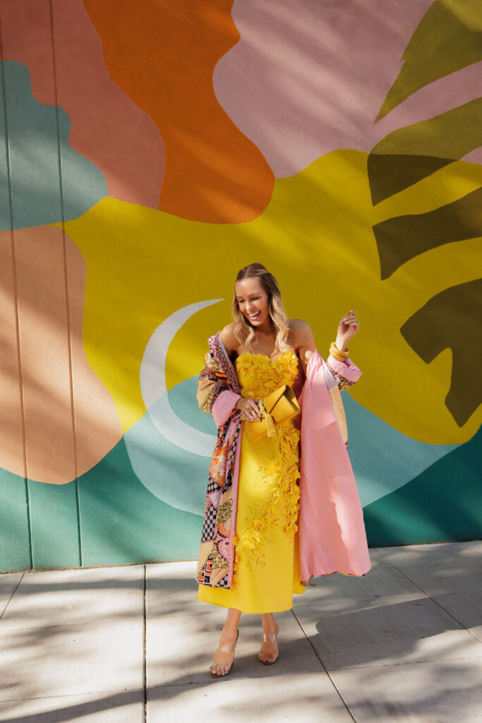 Marigold yellow floral appliqué dress styled with a Tuckernuck Gabrielle clutch for a statement fall fashion look.